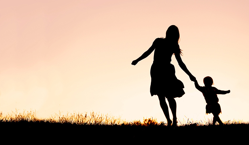Silhouette of Mother and Baby Daughter Running and Dancing at Sunset